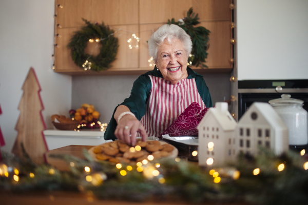 Happy senior woman baking a Christmas cakes.