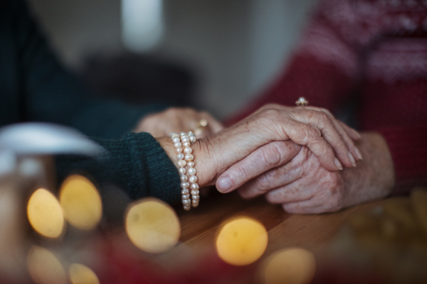 Close-up of seniors couple hands holding each other, during Christmas Eve.