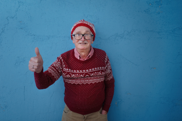 Portrait of happy senior man with Santa Claus hats in studio shoot.