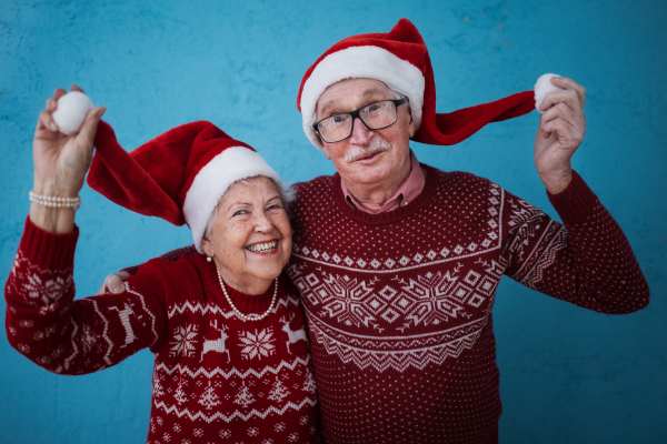 Portrait of happy senior couple with Santa Claus hats, studio shoot.