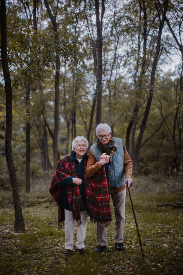 Senior couple walking together in autumn nature.