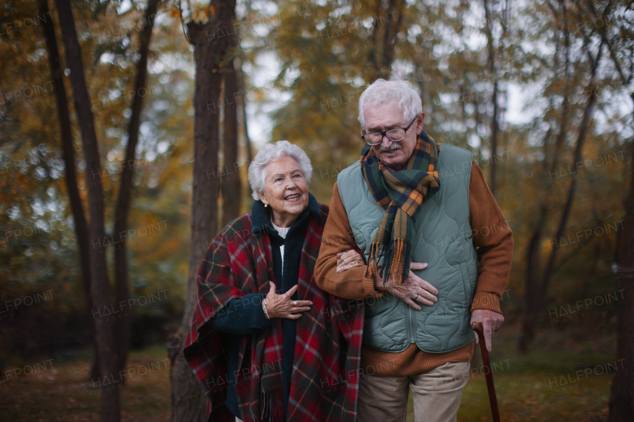 Senior couple walking together in autumn nature.