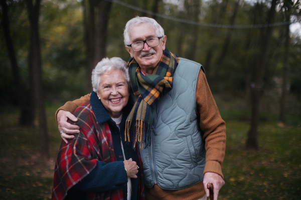 Portrait of senior couple walking together in autumn nature.