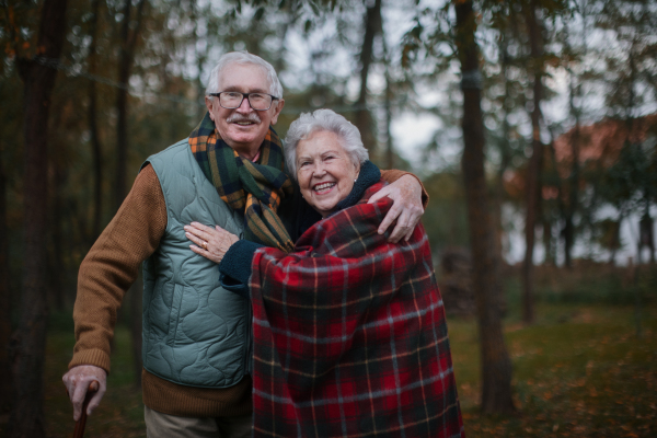 Portrait of senior couple walking together in autumn nature.