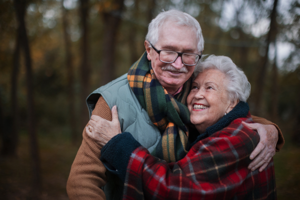 Portrait of senior couple walking together in autumn nature.