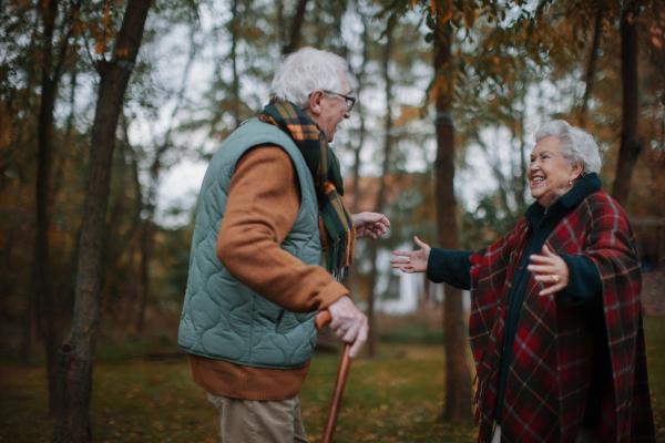 Senior couple greeting together in autumn nature.