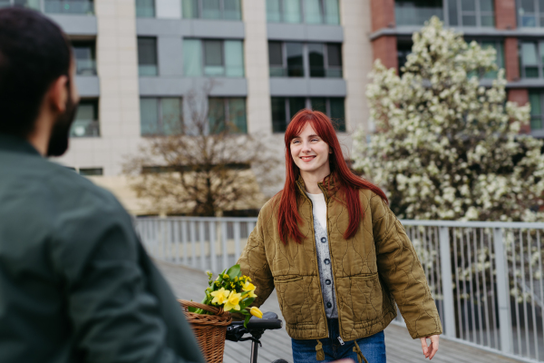 Girlfriend and boyfriend meeting in the city, greeting each other. Romantic date during cold spring day