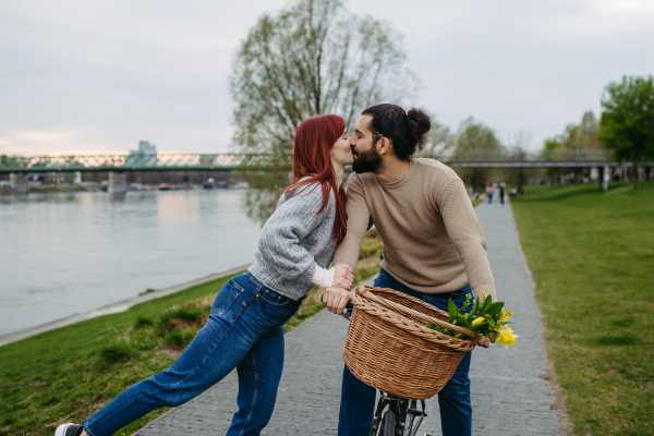 Girlfriend and boyfriend meeting in the city, greeting each other with hug and kiss. Romantic date during cold spring day.