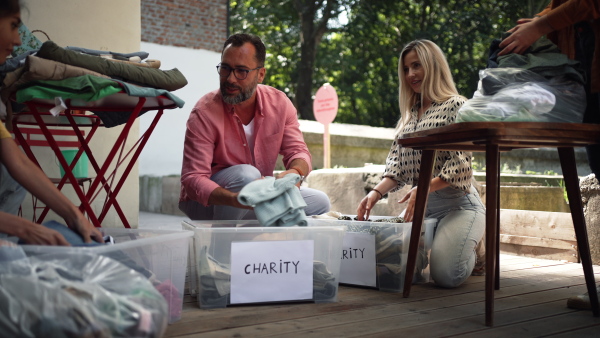 Video of volunteers sorting of clothes collected in a charity. Charitable work concept.