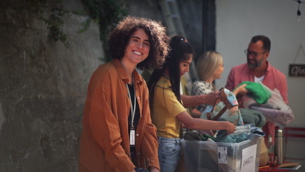 Video of volunteers sorting of clothes collected in a charity. Charitable work concept.