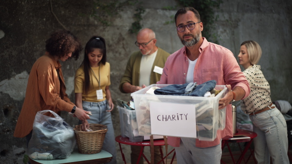 Video of volunteers sorting of clothes collected in a charity. Charitable work concept.