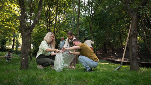 Video of group of volunteers picking up trash in the public park. Concept of integration of people with down syndrome.