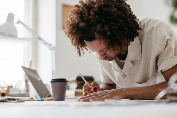 Young multiracial man drawing something in a designers studio.