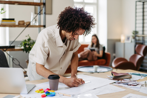 Young multiracial man drawing something in a designers studio.