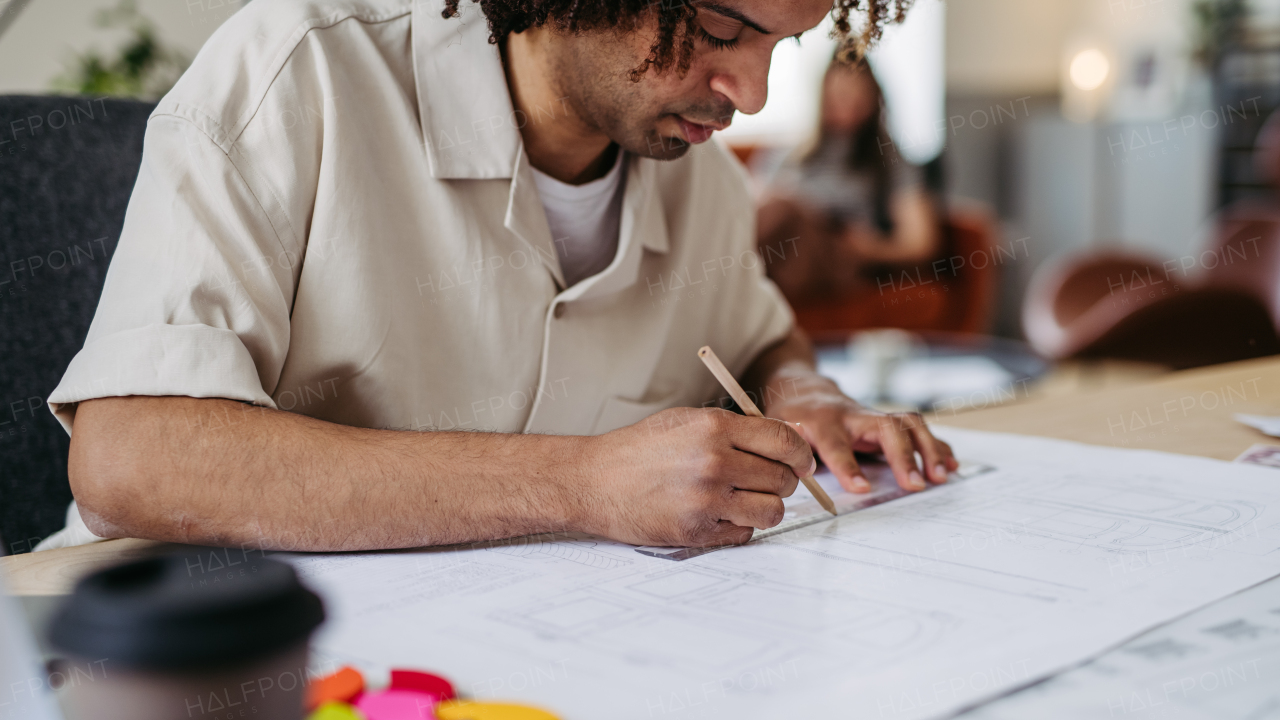 Young multiracial man drawing something in a designers studio.