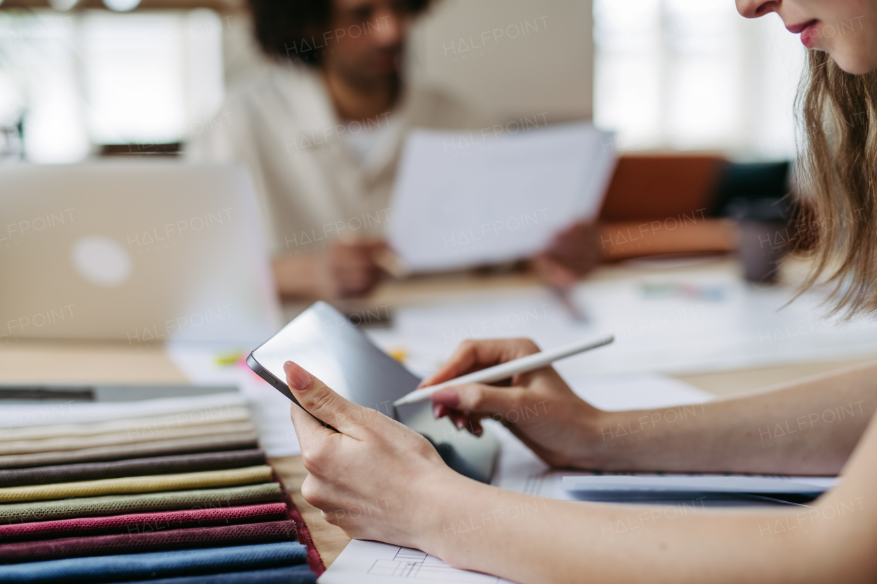 Close up of young colleagues working in a designers studio.