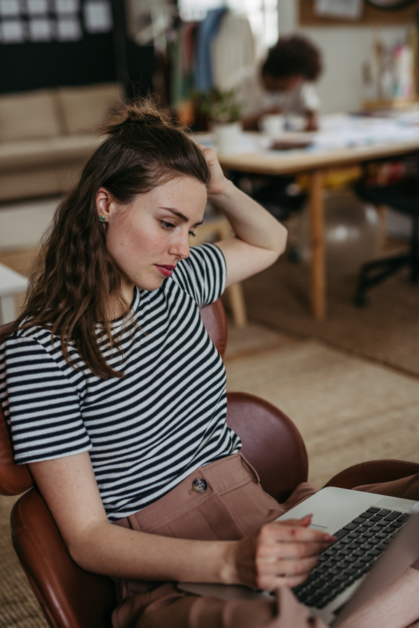 Young woman working on laptop in creative atelier.