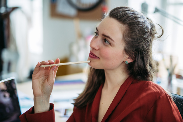 Portrait of a funny woman with pencil , having fun at work.