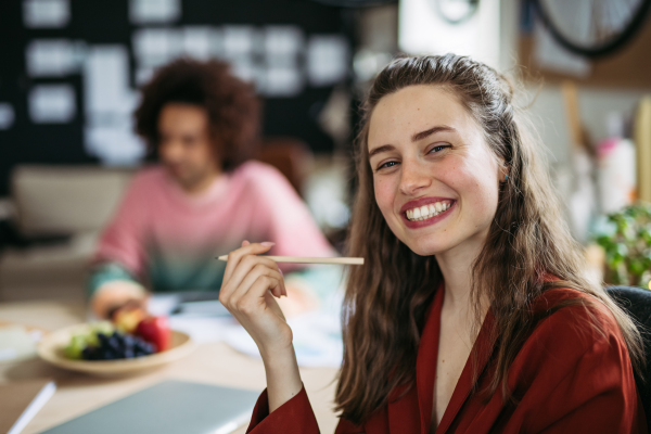 Young smiling woman with her colleague in office.