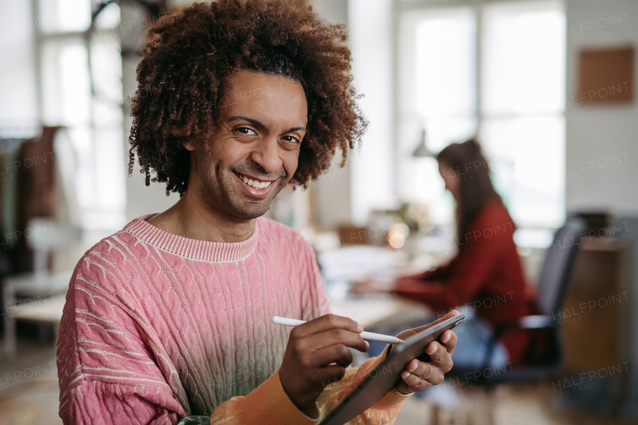 Portrait of young multiracial man drawing on a digital tablet.