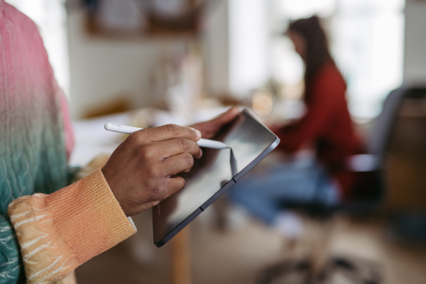 Close-up of young multiracial man drawing on a digital tablet.