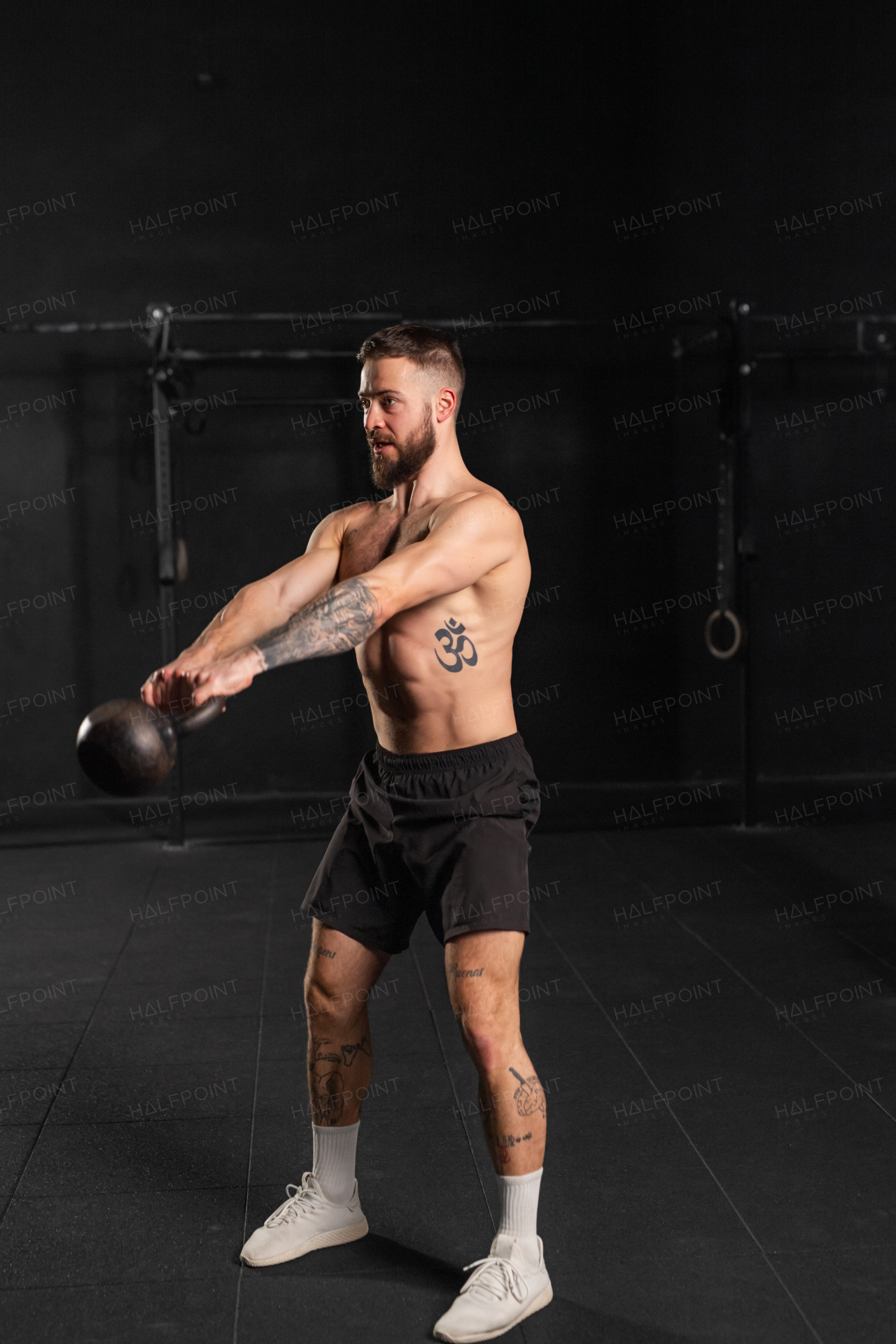 Man performing kettlebell swings, holding kettlebell in both hands. Strength exercise. Routine workout for physical and mental health.