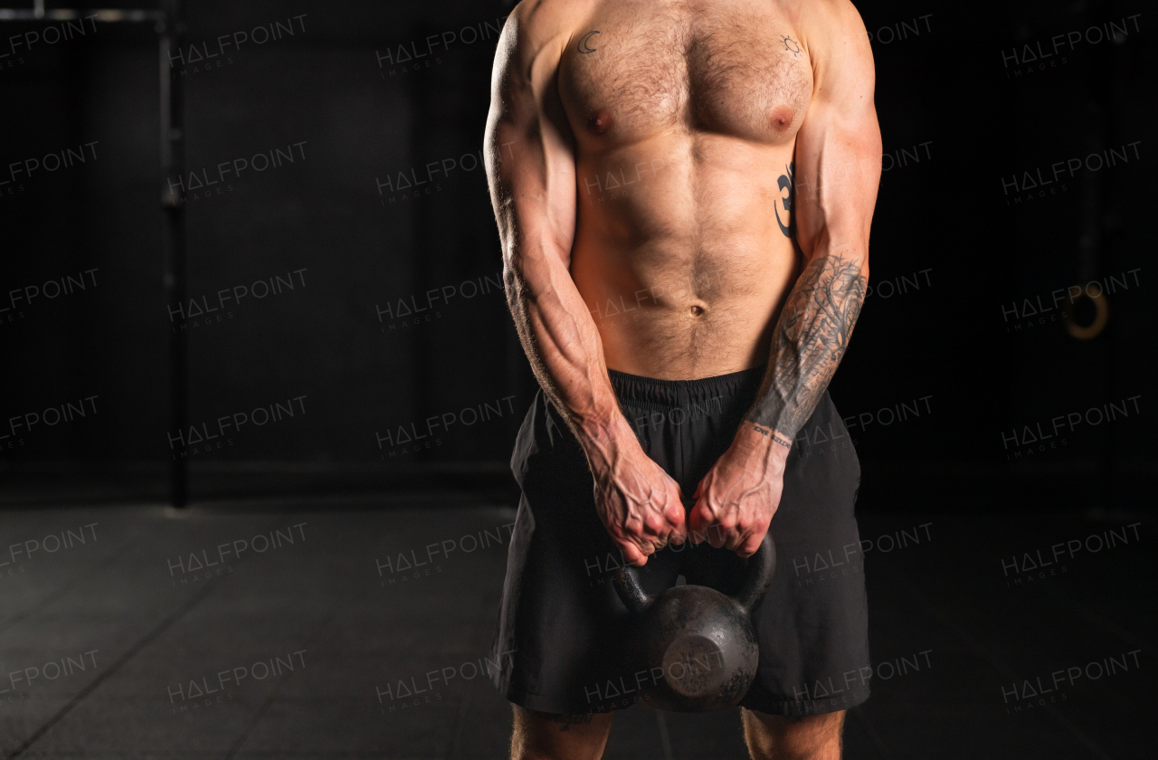 Man performing kettlebell swings, holding kettlebell in both hands. Strength exercise. Routine workout for physical and mental health.