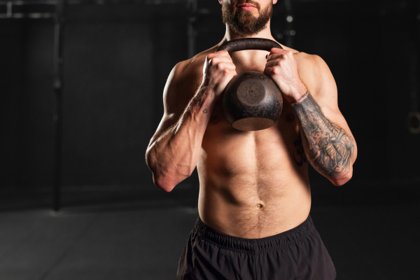 Man holding kettlebell in both hands. Strength exercise. Routine workout for physical and mental health.