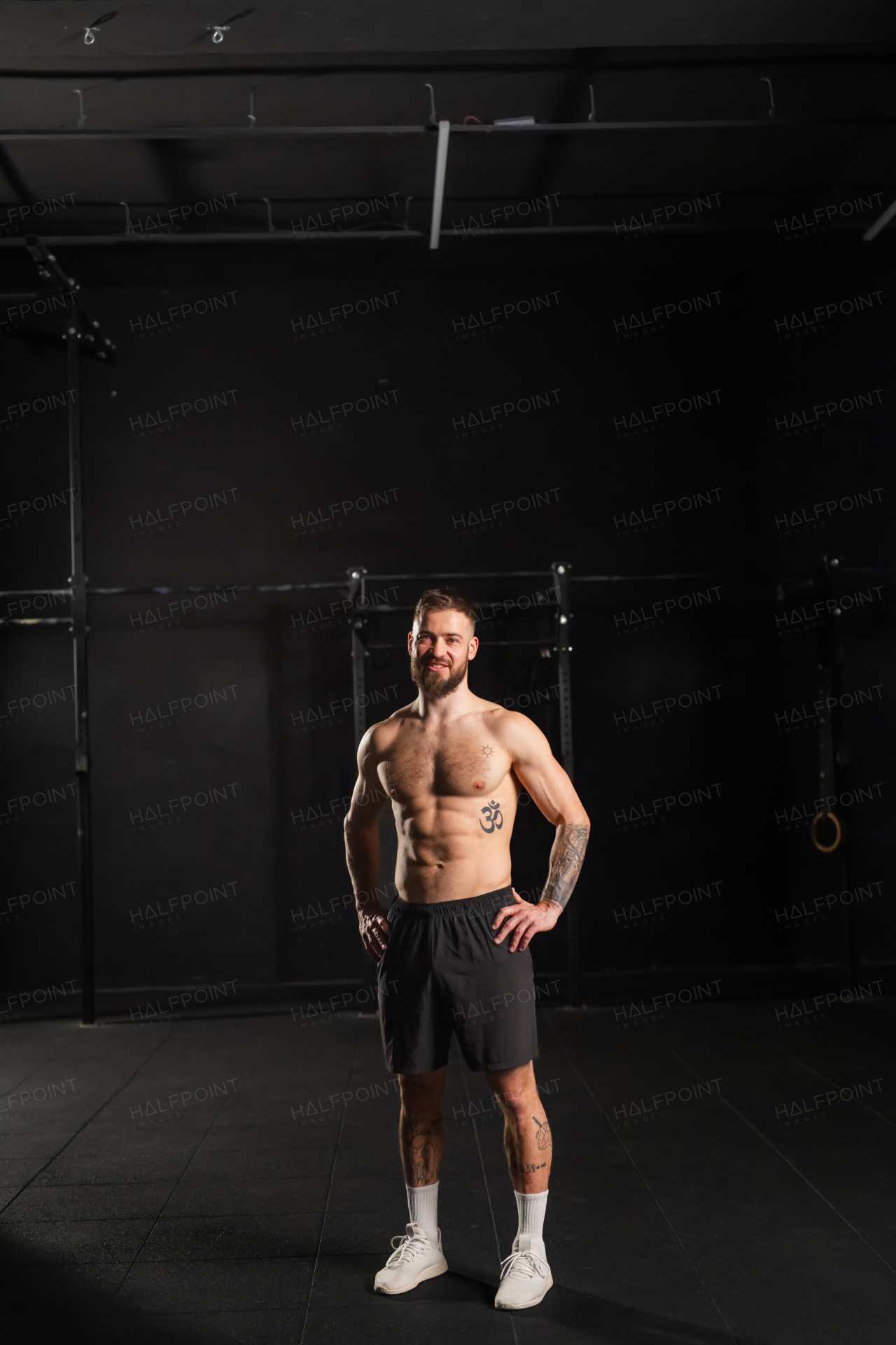 Portrait of handsome muscular man in gym with bare chest. Routine workout for physical and mental health.