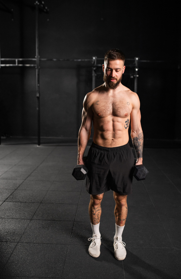 Man performing dumbbell lunge, holding dumbells in both hands. Strength exercise. Routine workout for physical and mental health.