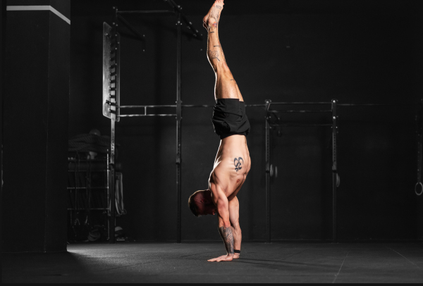 Rear view of handstand exercise, handstand push-ups by strong man. Vertical box jumps workout. Routine workout for physical and mental health.