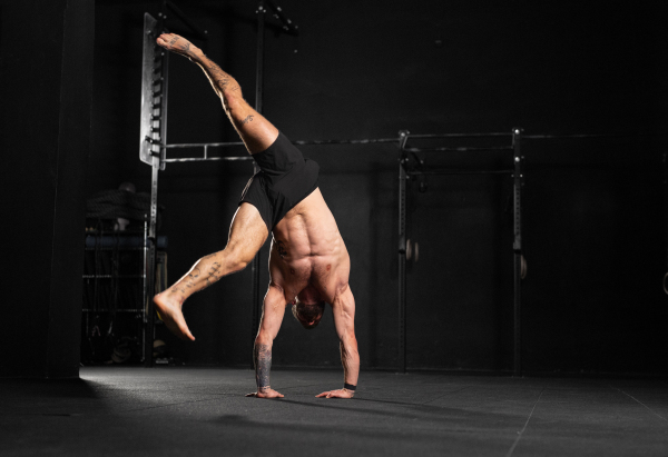 Rear view of handstand exercise, handstand push-ups by strong man. Vertical box jumps workout. Routine workout for physical and mental health.