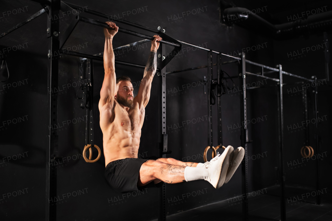 Strong man performing L-sit pull ups on bars, challenging bodyweight exercise. bodyweight workout for physical and mental health.