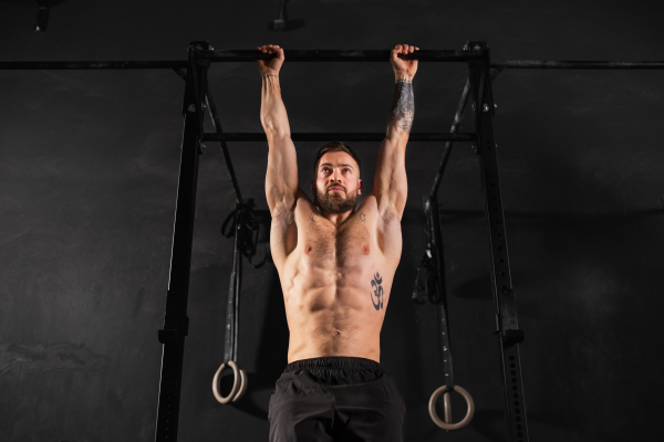 Strong man performing pull ups on bars, challenging bodyweight exercise. bodyweight workout for physical and mental health.