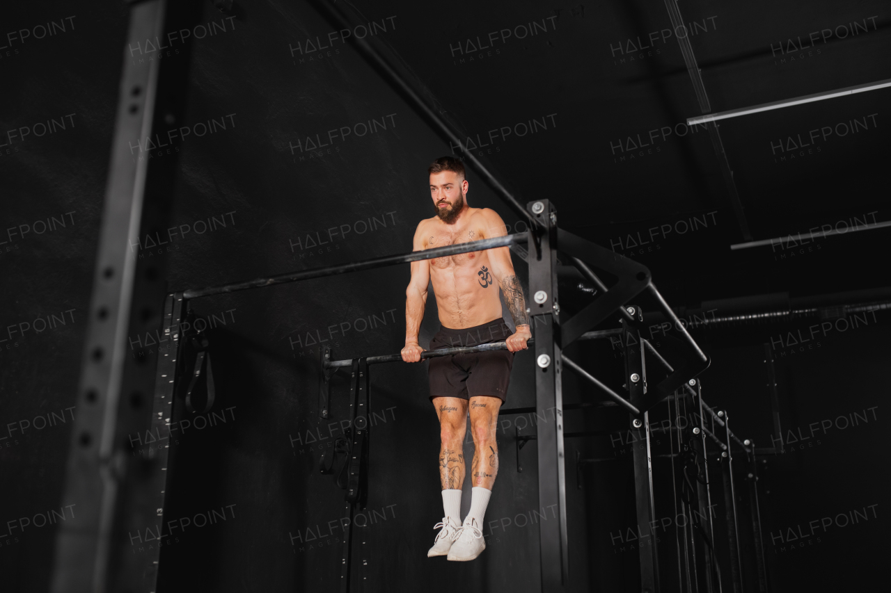 Strong man performing pull ups on bars, challenging bodyweight exercise. bodyweight workout for physical and mental health.