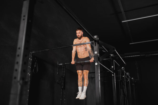 Strong man performing pull ups on bars, challenging bodyweight exercise. bodyweight workout for physical and mental health.