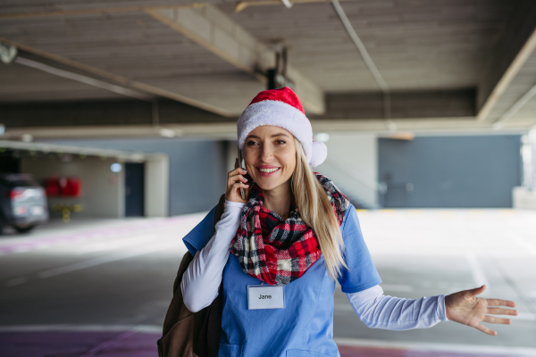 Portrait of beautiful nurse with christmas hat making call. Working in hospital on the Christmas day, Christmas Eve. Female doctor working a Christmas shift and can't be with her family.