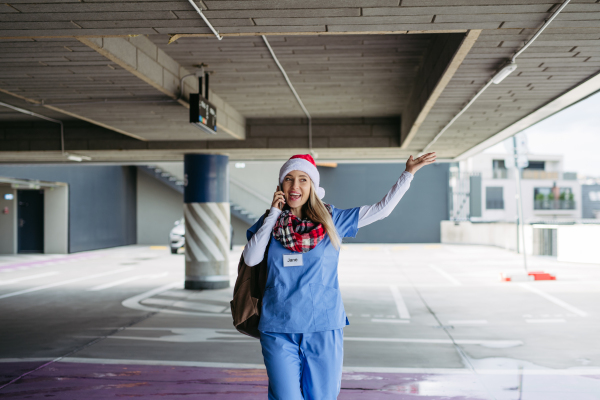 Portrait of beautiful nurse with christmas hat making call. Working in hospital on the Christmas day, Christmas Eve. Female doctor working a Christmas shift and can't be with her family.