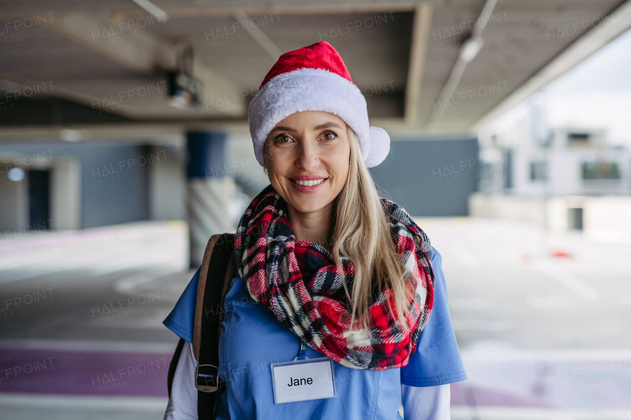 Portrait of beautiful nurse with christmas hat on head. Working in hospital on Christmas day or Christmas Eve. Female doctor working a Christmas shift and can't be with her family.