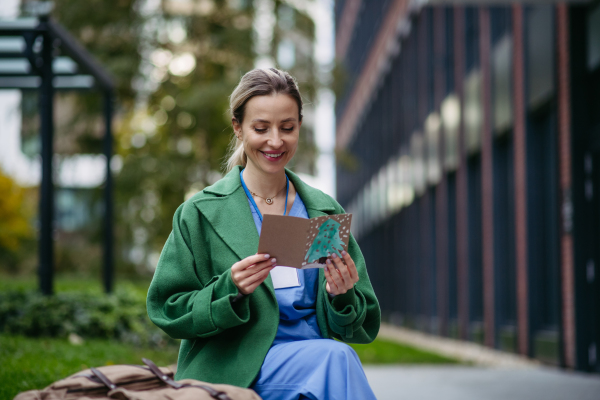 Nurse reading christmas card from child patient. Working in hospital on Christmas day. Female doctor working a Christmas shift and can't be with her family.