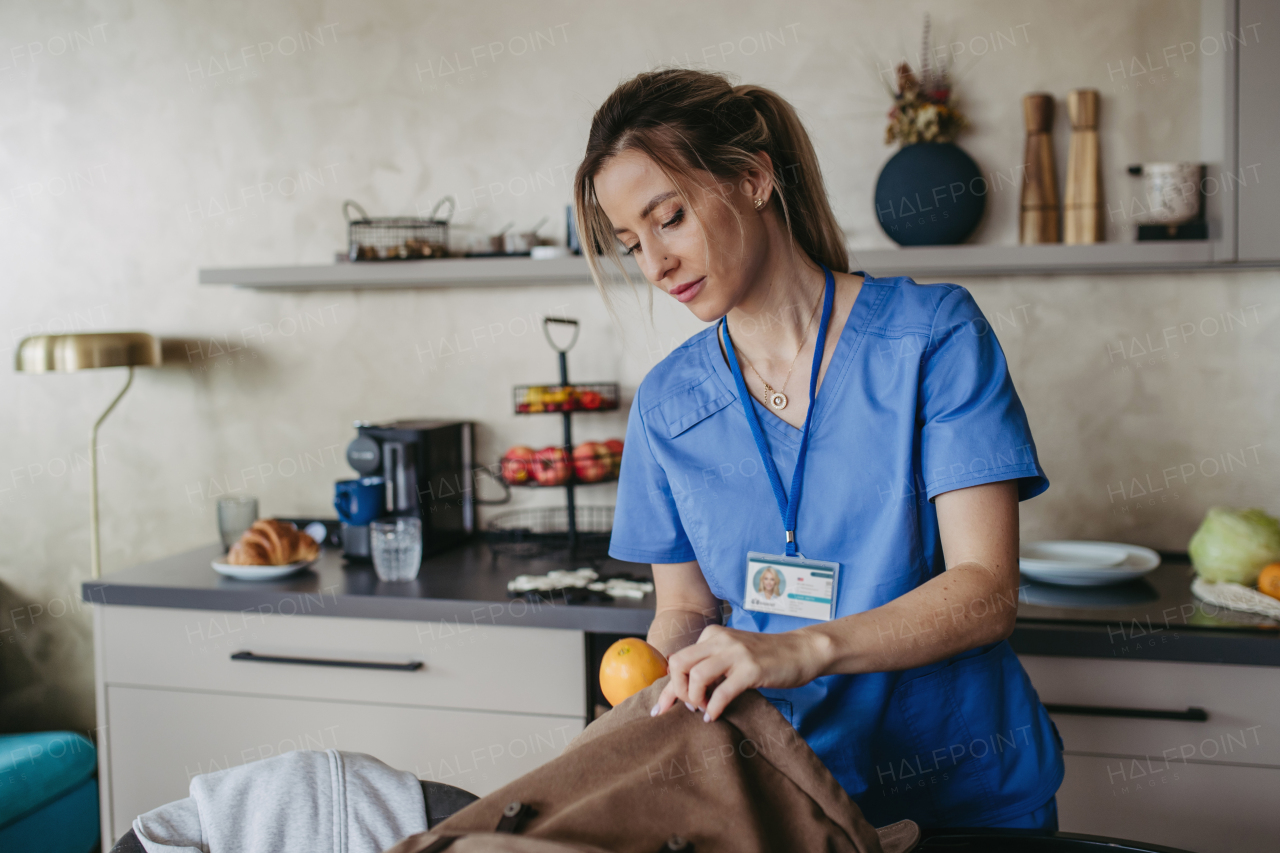 Female nurse, doctor getting ready for work, packing backpack, leaving house in scrubs with backpack. Work-life balance for healthcare worker.