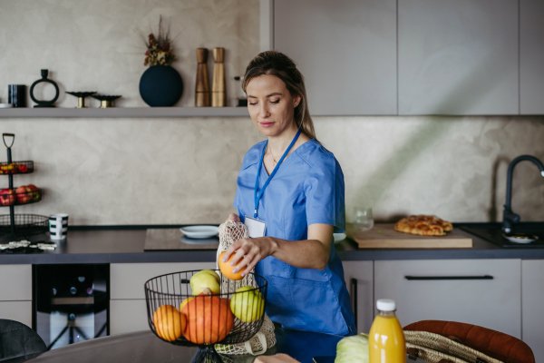 Female nurse, doctor returning home from work with groceries for family. Work-life balance of healthcare worker as parent and partner.