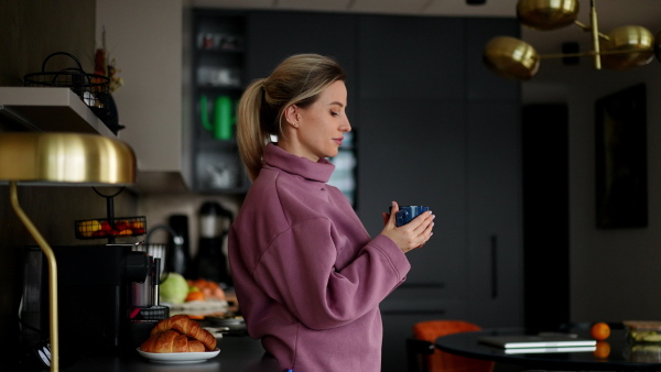 Female nurse, doctor getting ready for work, making breakfast and coffee on coffee maker. Work-life balance for healthcare worker.