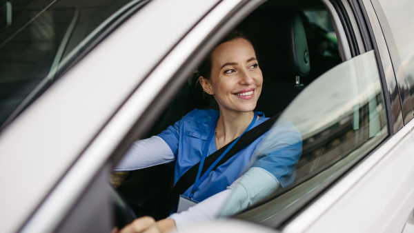 Female nurse sitting in car, going home from work. Female doctor driving car to work, on-call duty. Work-life balance of healthcare staff.