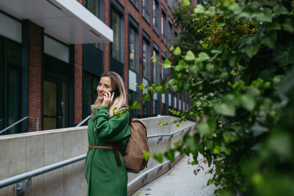 Female nurse or doctor going home from work, phone calling on smartphone. Work-life balance of healthcare worker.