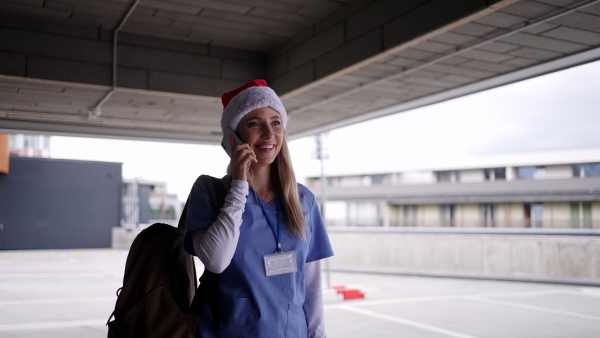 Video of beautiful nurse with christmas hat making call. Working in hospital on the Christmas day, Christmas Eve. Female doctor working a Christmas shift and can't be with her family.