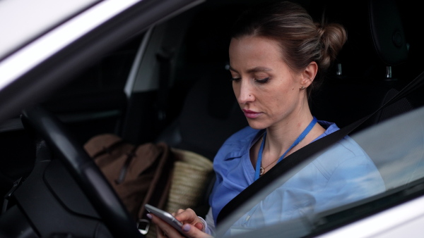 Female nurse going home from work, getting into car. Female doctor driving car to work, on-call duty. Work-life balance of healthcare worker as parent and partner.