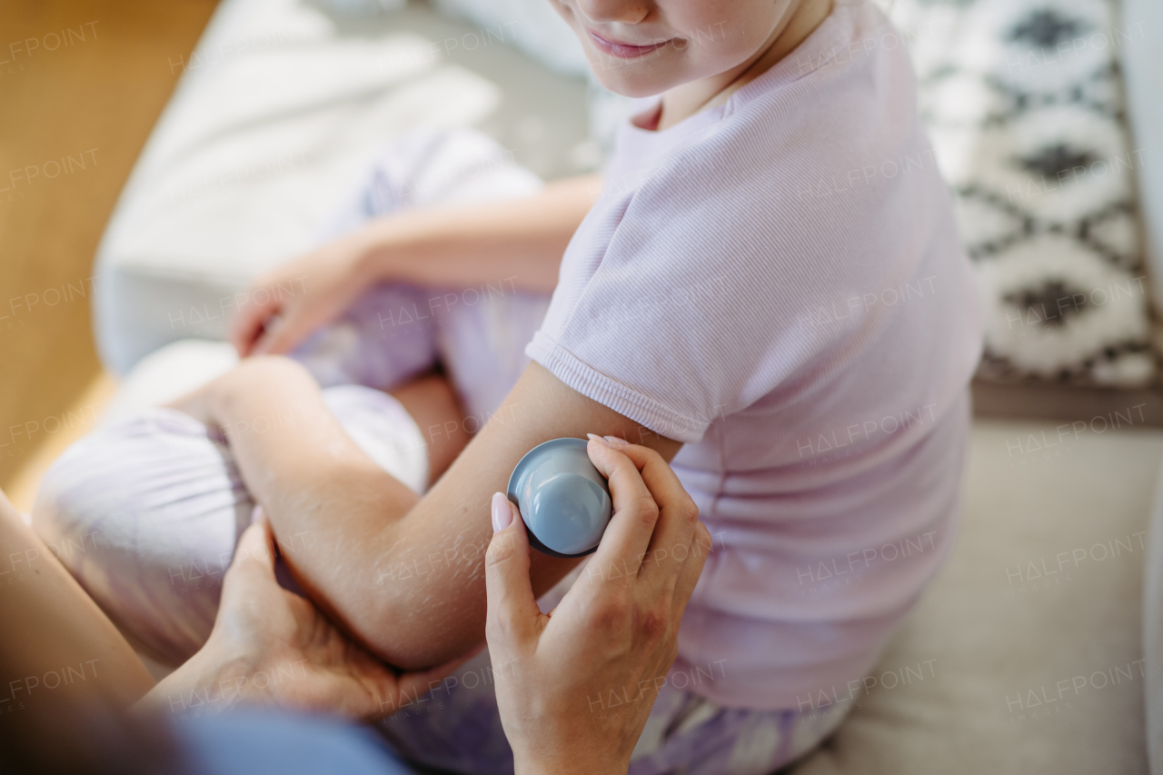 Close up of application of continuous glucose monitor sensor to the arm of a diabetic girl. CGM device making life of school girl easier, helping manage his illness and focus on other activities.