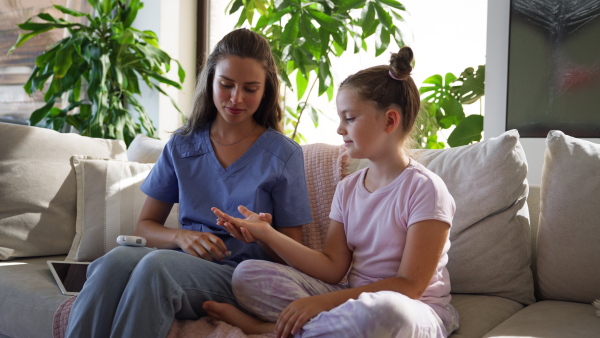 Nurse checking girl's blood glucose level using a fingerstick glucose meter. Endocrinologist waiting for results from his blood test.