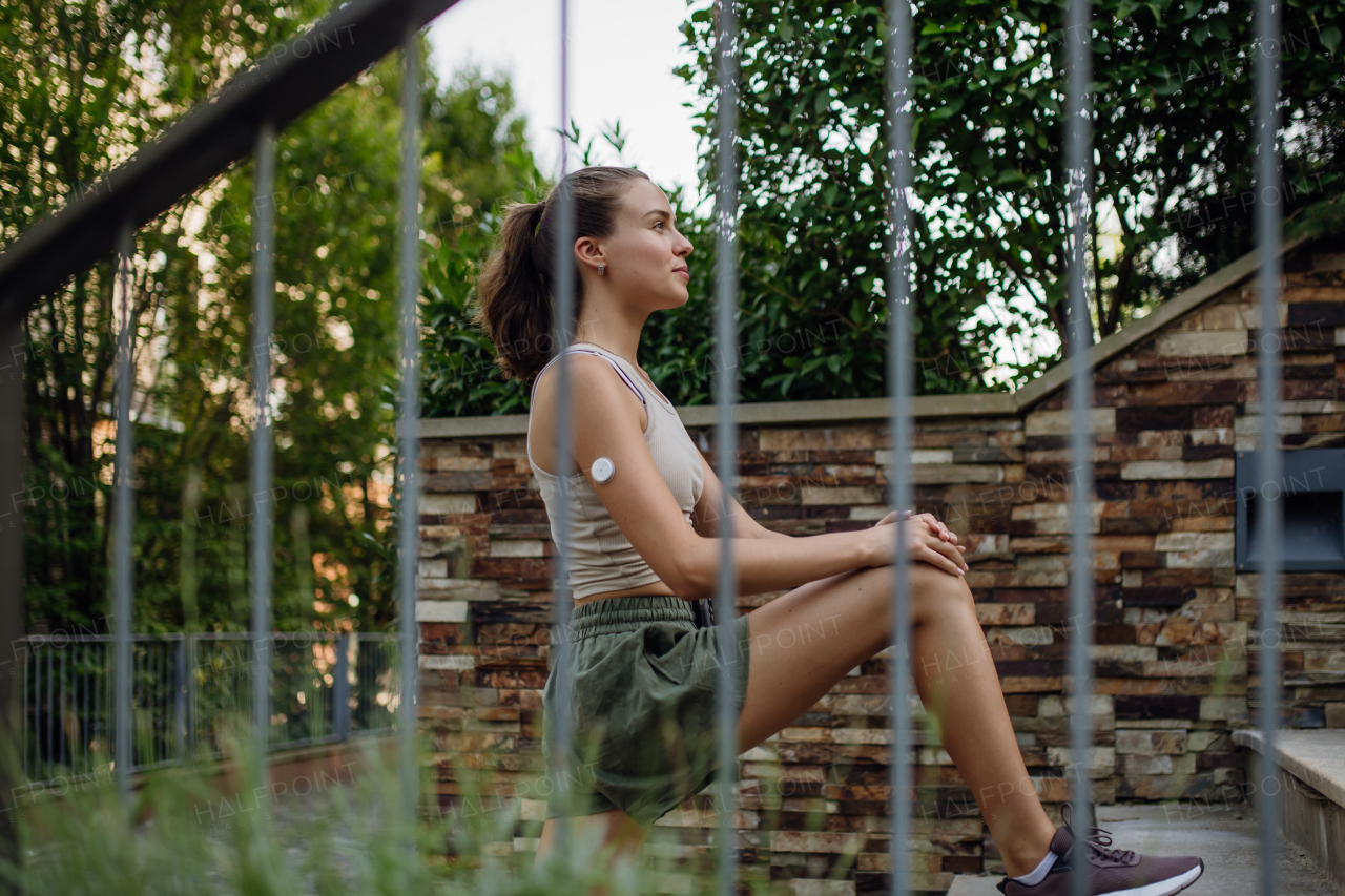 Beautiful diabetic woman preparing for outdoor workout in the city. Young woman wearing an insulin pump during exercising. Concept of exercise and diabetes. Banner with copy space.